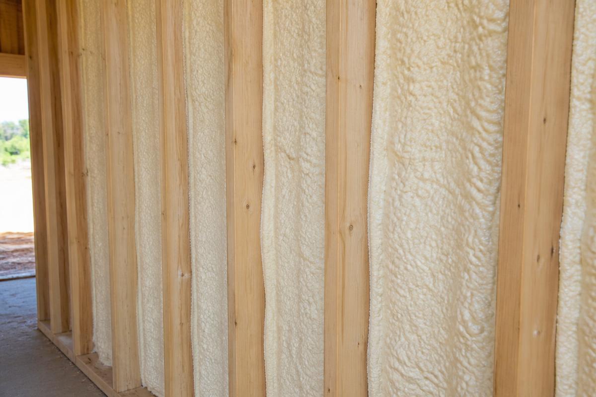Closed-cell spray foam insulation filling new-construction wall cavities